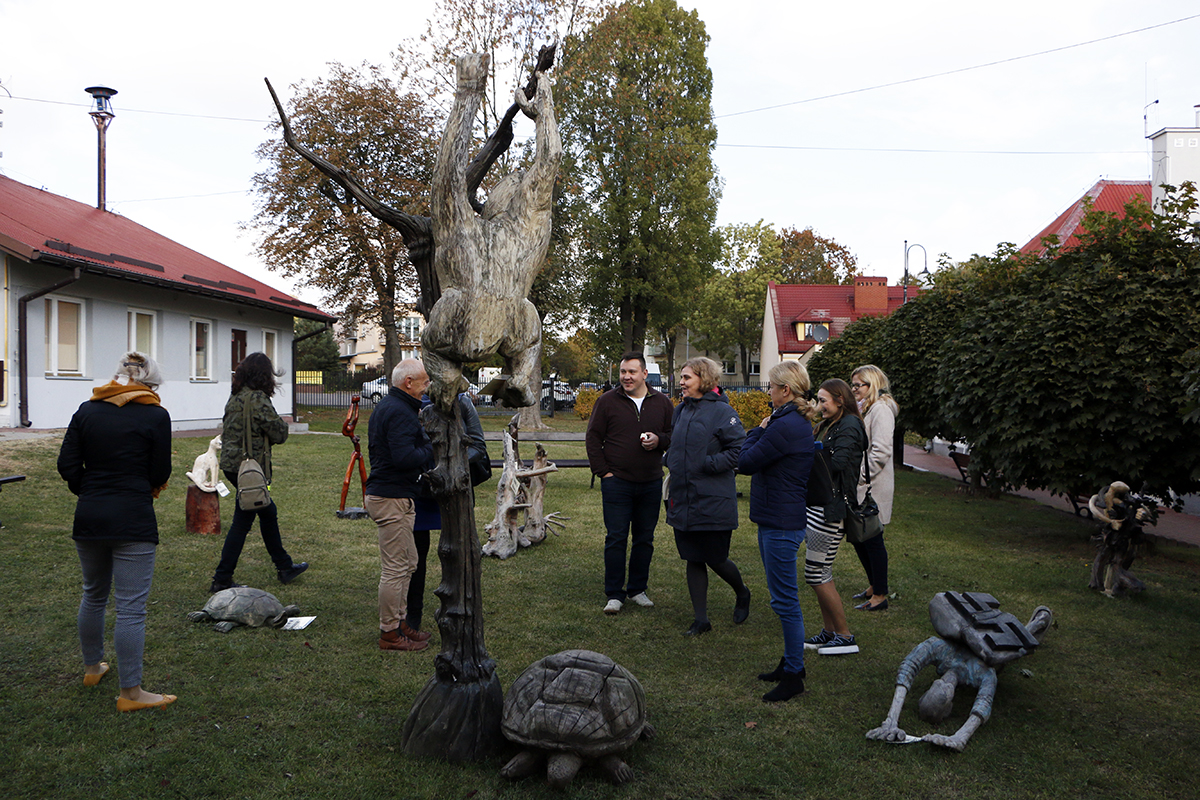 uczestnicy spotkania na trawników obok siedziby CKiCz w Serocku oglądają rzeźby Janusza Dłużniewskiego