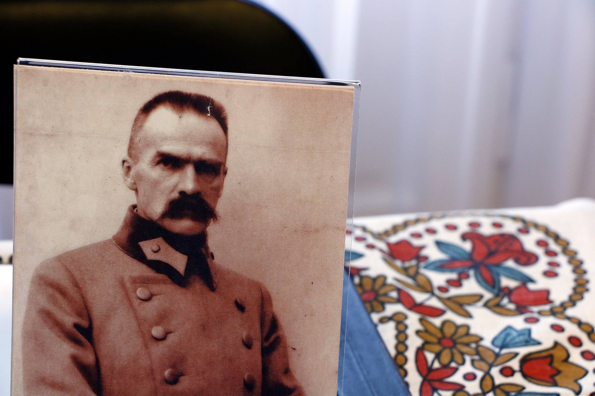 fotografia ukazująca portret marszałka Józefa Piłsudskiego ustawiony na stoliku w historycznym escape roomie